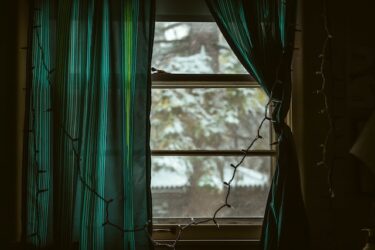 green curtains with snow outside window
